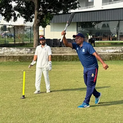 A coach demonstrates the correct form for a powerful shot. We believe in showing, not just telling, ensuring every player understands the fine details of technique in our group cricket coaching sessions.
