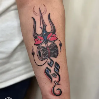 A custom design blending Lord Shiva's Trishul and Damru with a stylized Ganesha. The use of color highlights the lotus and adds a modern touch to these ancient symbols of power and new beginnings.