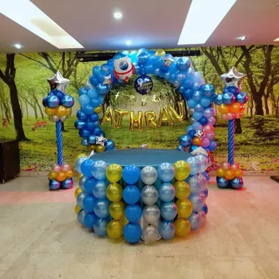 For a child who loves space, I designed this outer space-themed birthday decoration. The setup is built to look like a spaceship or planet, using blue, yellow, and silver balloons, with a rocket ship and star-shaped foil balloons to complete the astronaut theme.