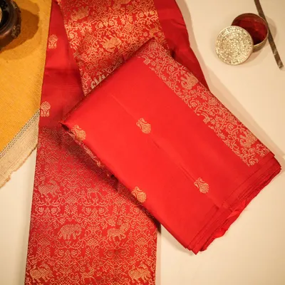 A quintessential bridal saree, this radiant red Kanjivaram is woven with a grand pallu featuring majestic elephants and horses in pure gold zari, telling a story of royalty.