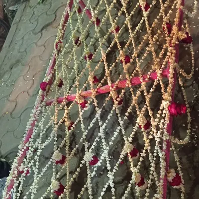 A close-up of a 'Dulhaniya Chaadar' I made for a bride's entrance. It is woven in a net pattern using fragrant white rajnigandha (tuberose) strings with accents of red and white roses.