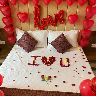 A romantic bedroom setup where I used rose petals to write "I ❤️ U" on the bed, perfect for an anniversary or Valentine's Day surprise.