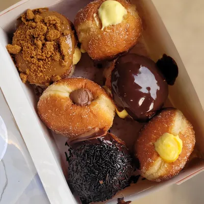 This is the Ultimate Box for a reason. It’s an assortment of my all-time best seller bombolinis, including Biscoff Crunch, Double Chocolate Boston Creme, and classic custard. The flavors change with the seasons, so there's always something new to try.