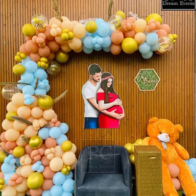 A "We Can Bearly Wait" teddy bear themed baby shower backdrop. A custom cutout of the parents-to-be is the centerpiece, surrounded by a beautiful balloon arch in pastel blue, yellow, and peach.