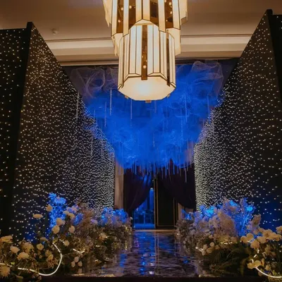 Step into a celestial sangeet through this magical entrance. I designed this passageway with walls of twinkling fairy lights and a ceiling of ethereal blue mesh, creating the feeling of walking through a starry night sky to reach the celebration.