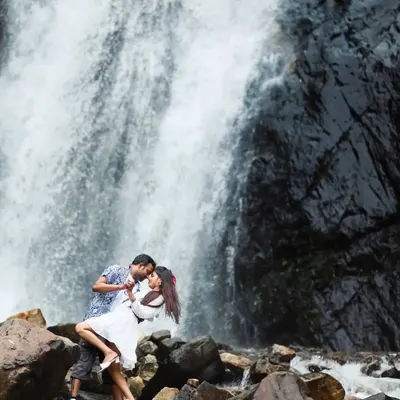 A classic romantic pose in front of a stunning waterfall. The power of the water and the intimacy of the couple's embrace create a beautiful and timeless pre-wedding photo.