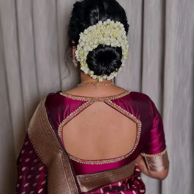 A classic gajra bun is the epitome of traditional elegance. This beautifully crafted hairstyle, full of fresh jasmine, perfectly complements a silk saree for a timeless wedding look.