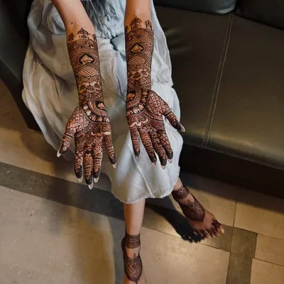 A complete view of a full bridal mehndi set. The design features matching motifs on the hands and feet, creating a harmonious and traditional look for the bride.