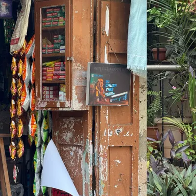 A fading corner that's seasoned by stories. This shot of a small kirana store, with its weathered wooden cabinet and hanging snacks, captures the timeless charm of neighborhood life.