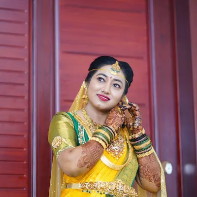 A beautiful South Indian bride in a yellow and green silk saree, her hands adorned with my mehendi. The rich henna stain looks stunning against her traditional gold jewelry.