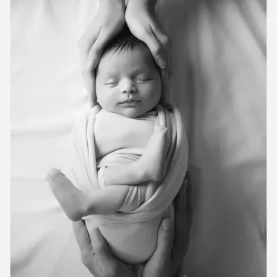 A black and white version of one of my signature shots. The absence of colour makes the loving hands holding the baby even more impactful.