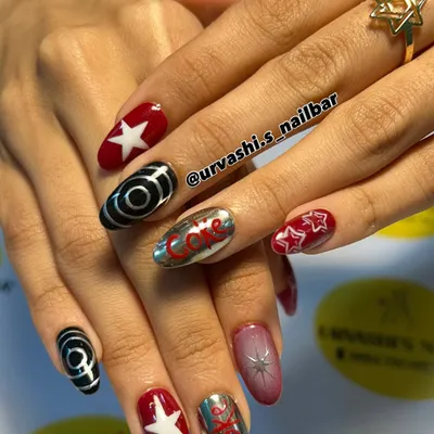 A retro and fun set inspired by Coca-Cola. I combined the iconic logo on a chrome nail with bold red, stars, and graphic black and white swirls for a pop-art vibe.