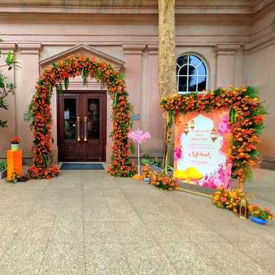 For this unique Haldi ceremony, I designed a vibrant entrance with a Turkish-inspired theme. The floral arch is made of bright orange and yellow marigolds, perfectly complementing the custom-designed welcome signage.