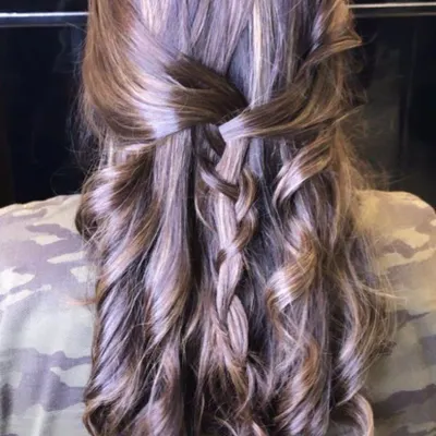 A beautiful and intricate hairstyle for a party or pre-wedding event. This half-up, half-down look features a waterfall braid and soft curls, adding a touch of romance and elegance.