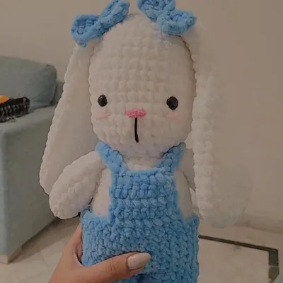 Meet Fluffy, a custom-ordered bunny plushie. This amigurumi toy features adorable details like handmade blue overalls and matching bows, all crafted from soft white yarn for the perfect huggable friend.