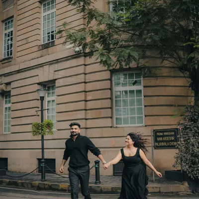 A fun, energetic shot of a couple running and laughing on a Mumbai street. This image captures the carefree spirit of their love story against an urban backdrop.