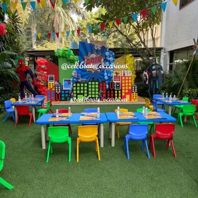 A full view of a superhero-themed party featuring our colorful rainbow chairs and blue tables. The vibrant furniture perfectly complements the dynamic decor, creating an action-packed setting.