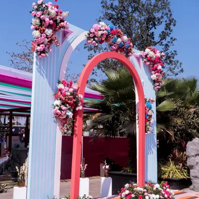 The floral-adorned entrance arch for our 'Art in the City' carnival, blending pastel stripes and bold colors for a whimsical welcome.