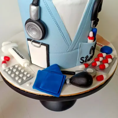 A closer look at the details on my doctor-themed cake. You can see the tiny blister pack of pills, the syringe, and the blood pressure cuff, all handcrafted from fondant to celebrate the healing profession.