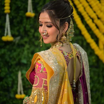 A truly authentic Maharashtrian engagement look. The makeup is soft and radiant, with attention to the eyes and the traditional mundavalya and earchain. The yellow and pink saree combination is vibrant and celebratory.