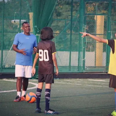 Coach Mani provides specific instructions to two of our academy players during a practice session. This kind of focused, one-on-one feedback helps refine technique and build player confidence.
