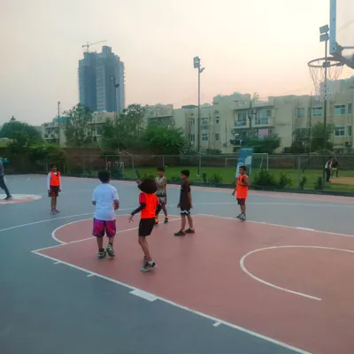 An action shot from the Under-10 basketball match between Warriors and Insfire. This shows a live game situation with players moving the ball on an outdoor court.