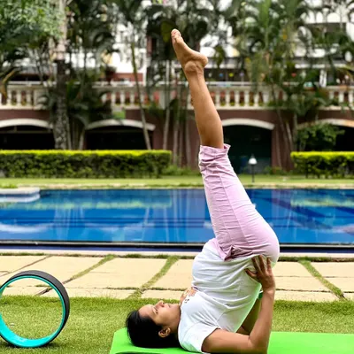 A gentle shoulder stand (Sarvangasana) practiced outdoors. This inversion is modified to be safe and beneficial during pregnancy, improving circulation.