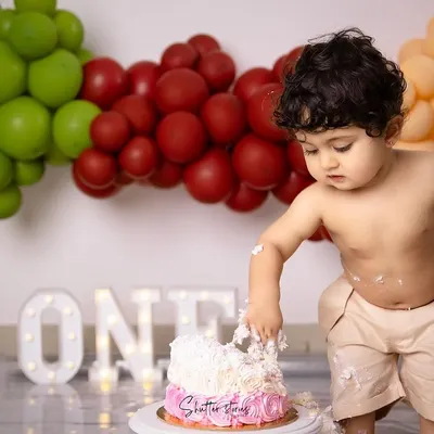 The sweetest milestone and the messiest memories! This little guy is having a blast digging into his first birthday cake.