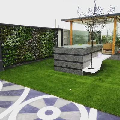 This is a prime example of a complete terrace transformation. We installed soft artificial grass, a full-sized artificial green wall for privacy, and arranged the space around a central water feature and gazebo.