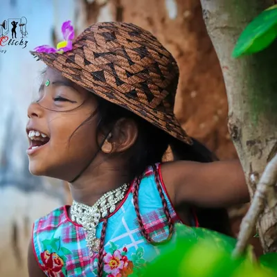 The sound of pure, uninhibited laughter captured in a photo. This candid outdoor shot of a young girl enjoying the moment is what natural light photography is all about.