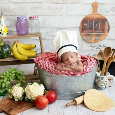 Cooking up some cuteness in the studio! This little chef is the main ingredient in our recipe for a perfect newborn photo, complete with a tiny chef's hat and a kitchen full of props.