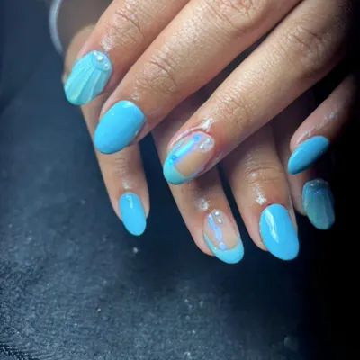 For clients who love a pop of color and creativity, this design features a vibrant sky blue gel polish. I've added unique details like a 3D seashell accent on one nail and a "glass" or negative space effect on another, decorated with delicate pearls for a modern, ocean-inspired look.