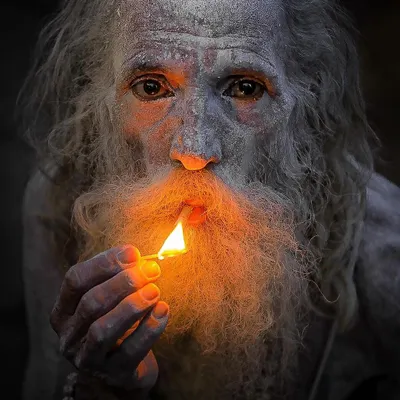 A sadhu's face illuminated only by the flame of a matchstick. This portrait uses light and shadow to create a sense of mystery and deep contemplation, a signature style in my work.