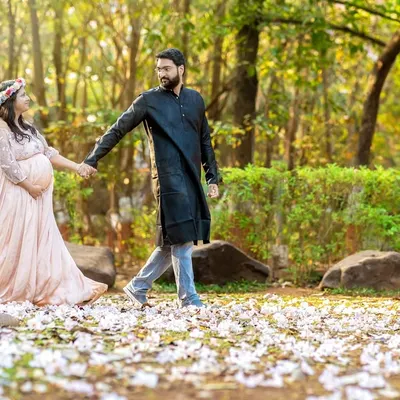A romantic walk through a field of fallen blossoms. This shot captures the couple hand in hand, creating a beautiful narrative of their journey together in a stunning natural setting.