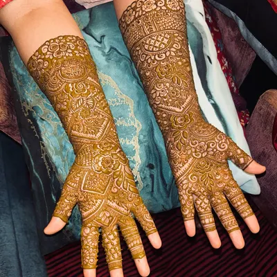A classic, full-coverage Indian mehendi design. The patterns are dense and detailed, featuring traditional motifs that extend to the elbows.