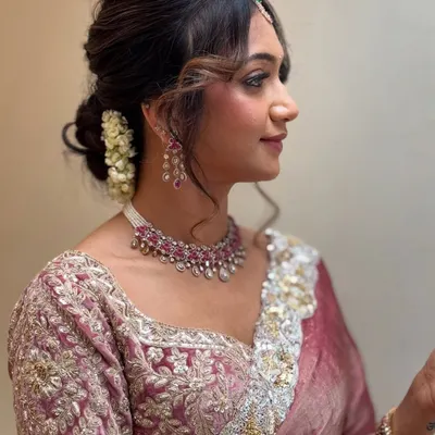 A gorgeous and modern look for Monica. We chose a soft glam style with a messy bun adorned with flowers, perfect for her elegant designer saree. This look is completely filter-free.