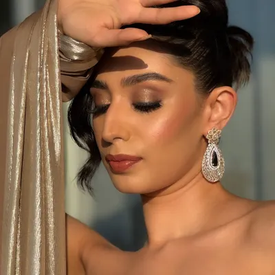 This is the epitome of cocktail glam meeting golden hour. The warm, bronzy tones on the eyes and the radiant highlighter on the cheeks are designed to catch the sunset light perfectly.