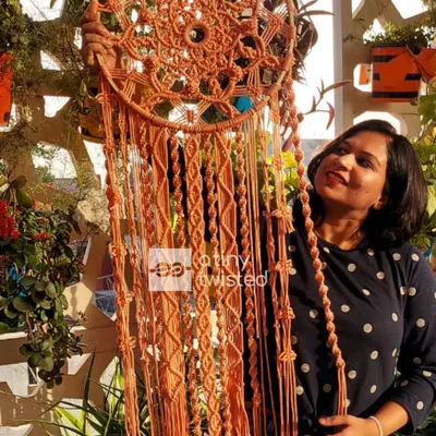 Holding up this 4-foot-tall dreamcatcher gives a true sense of its scale. The intricate knotting in the center contrasts beautifully with the long, flowing tassels.