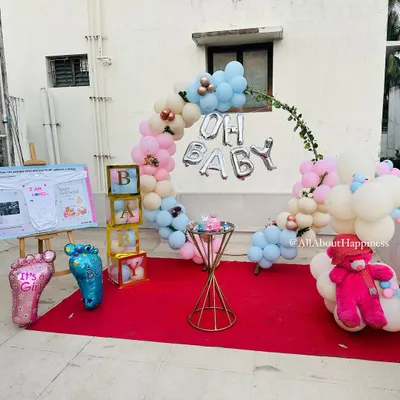 A beautiful 'Mottamadi' or terrace baby shower setup. The decor includes a lovely balloon hoop, 'Oh Baby' foil balloons, and a personalized easel board.