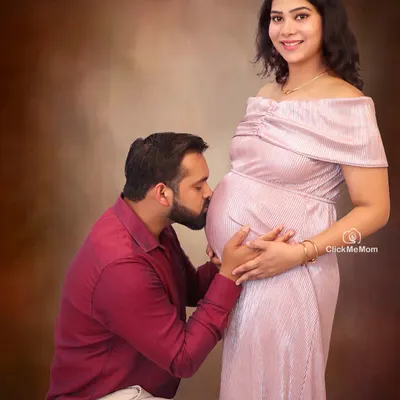 A tender kiss for the precious life within. This pose is a beautiful way for partners to show their love and anticipation for the baby. It creates a classic and emotional family maternity portrait that you will cherish forever.