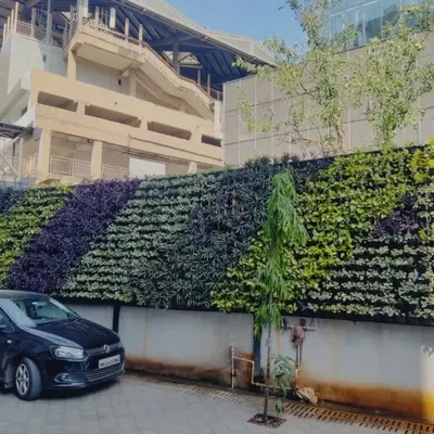 This large-scale exterior green wall uses a diagonal pattern of purple and green foliage to create a dynamic visual effect. It's a powerful way to beautify large structures and make a positive environmental impact.