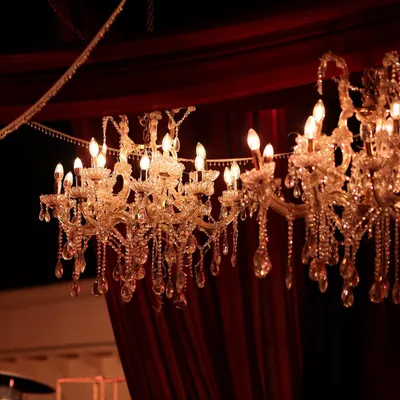 Crystal chandeliers hanging against rich, red velvet drapes. This combination of textures and the warm, sparkling light created an atmosphere of pure opulence and romance for this sundowner wedding.