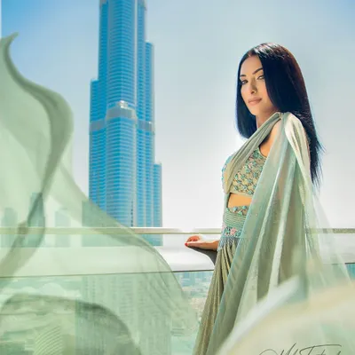 A stunning shot from a Dubai balcony, with the wind catching the fabric of the model's gown. This image combines fashion with a world-class location to create a truly aspirational photo.
