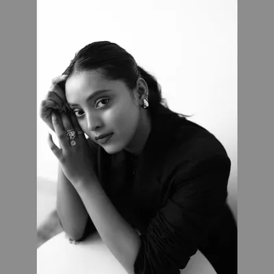 A classic black and white portrait where the simplicity of the composition emphasizes the model's striking features and direct gaze. This timeless style is perfect for actor headshots or fashion portfolios.
