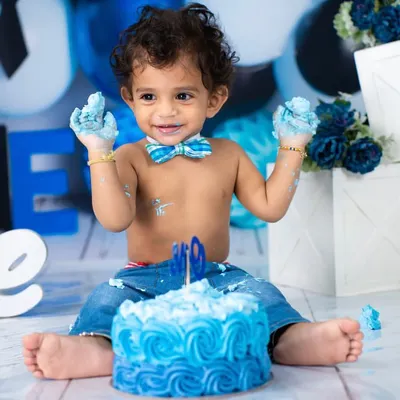 Hands full of cake and a heart full of joy! This little guy is having the best time during his blue-themed "Boss Baby" cake smash, a perfect way to celebrate his first birthday.
