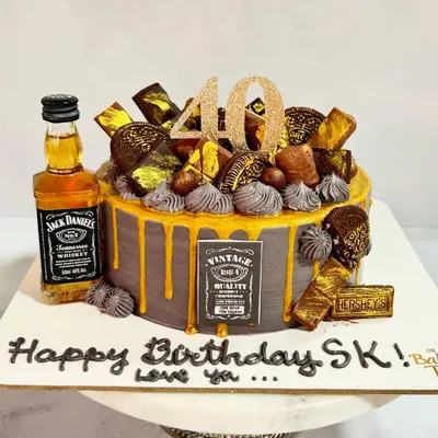 Turning 40 never looked so delicious! This Jack Daniel's themed cake is perfect for a milestone celebration, featuring a miniature bottle, chocolate decorations, and a gold drip.