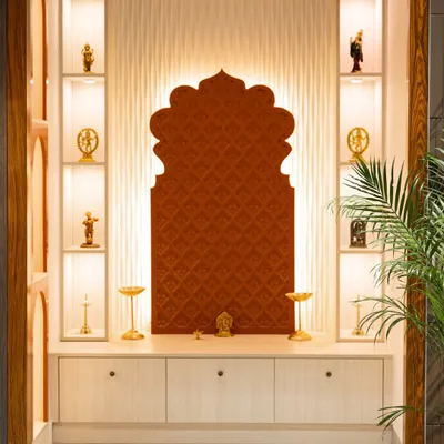 A beautifully lit pooja unit from my Hyderabad Experience Center. It features a traditional arch-shaped backdrop, backlit display shelves for idols, and concealed storage below.