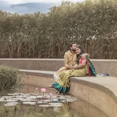 A serene outdoor scene with the couple sitting by a lily pond, creating a peaceful and romantic atmosphere.