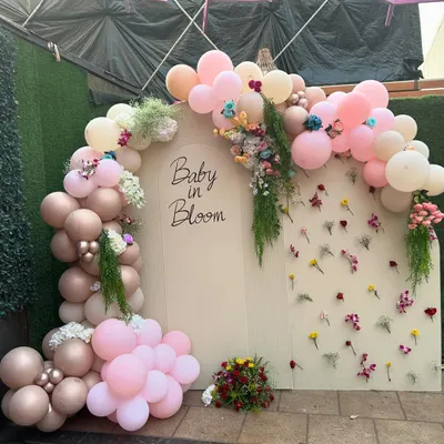 A 'Baby in Bloom' backdrop designed for a Godh Bharai ceremony, combining a modern balloon arch with a wall of delicate, individually placed flowers.