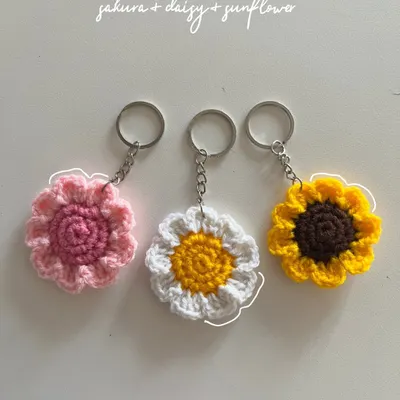A vibrant set of my most popular flower keychains: a pink sakura, a classic white and yellow daisy, and a sunny sunflower. Each petal is carefully crocheted.